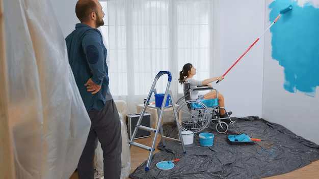 Professional painter working on interior walls with proper equipment and setup